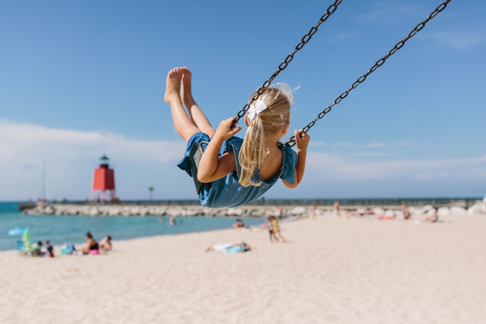 Little girl on a swing at Michigan Beach Park in Charlevoix, Michigan
